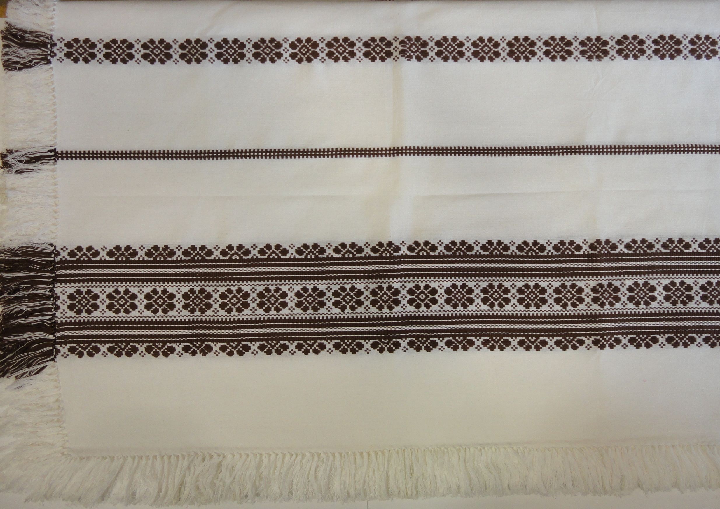 311. Szőttes terítő, fehér alapon hagyományos mintával, barna beszövéssel, rojtos 140 x 200 cm
